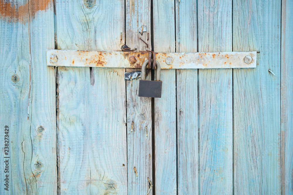 The background with old colored in blue wooden gate with lock The background with old colored in blue wooden gate with lock