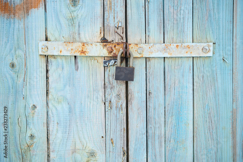 The background with old colored in blue wooden gate with lock © Alexander