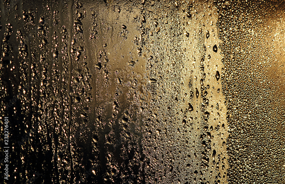 Drops of water on the glass, closeup. Golden abstract background. Beautiful texture. Background image for design. Drops of water on the glass, closeup. Golden abstract background. Beautiful texture. Background image for design.