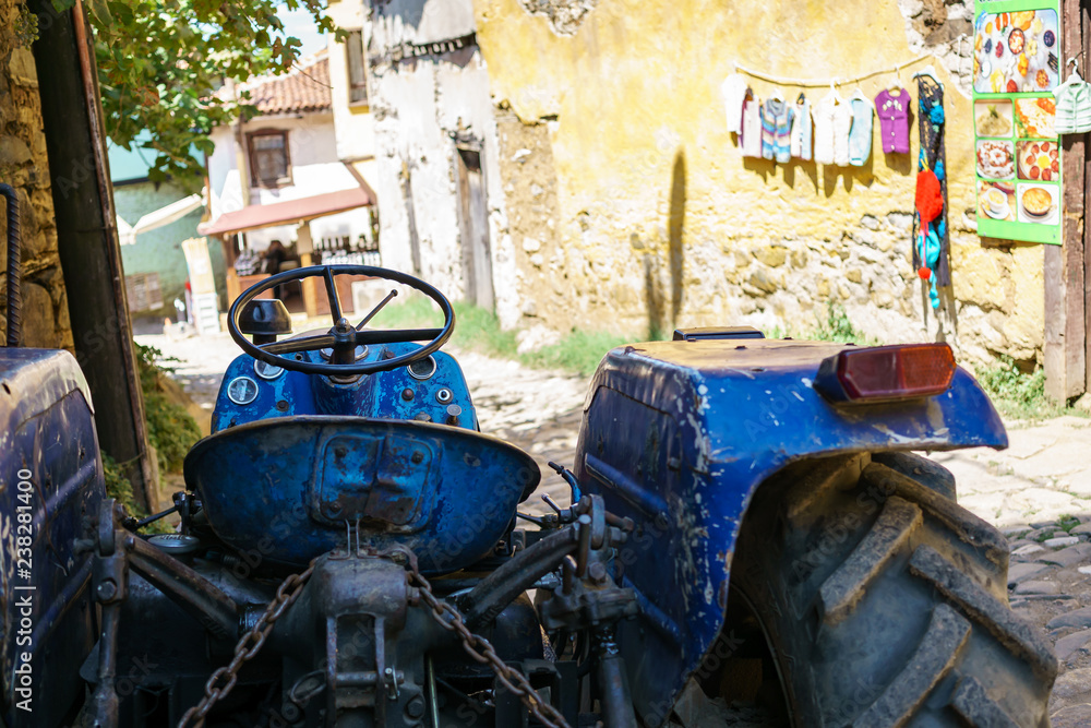 Blue tractor on a narrow streen in Cumalikizik, Bursa, Turkey Blue tractor on a narrow streen in Cumalikizik, Bursa, Turkey
