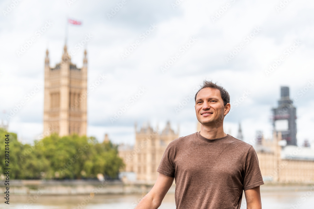 Fototapeta premium London, UK happy smiling young man face and cityscape skyline of city with Thames River, Westminster during cloudy day on Albert Embankment