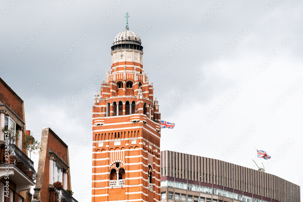 London Westminster Cathedral tower and flags buildings near Victoria station in the United Kingdom, closeup of church dome with cloudy sky