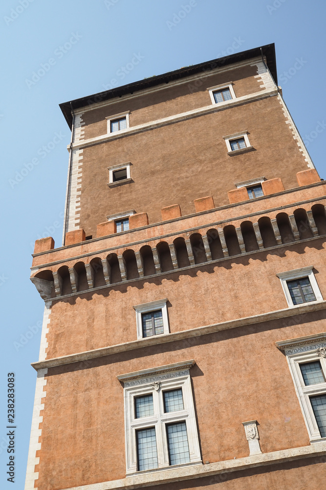 Roman architecture, tower with orange mediterranean facade and windows