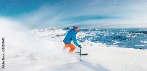 Alpine skier skiing downhill, panoramic format
