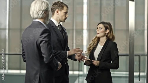 A couple of bussinessmen and bussines woman discussing an important topic