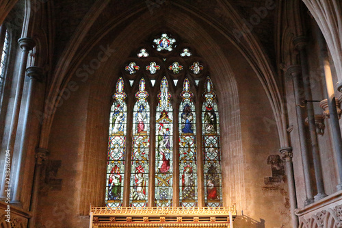 A pointed arch  stained glass window with Gothic decorations in the Bristol Cathedral  in United Kingdom
