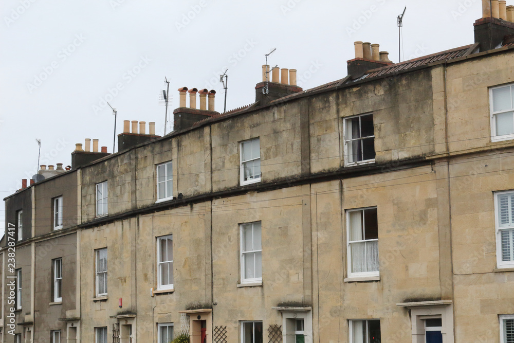 Beige terrace houses with sash hung windows and chimney stacks in a cloudy day in Bristol, United Kingdom