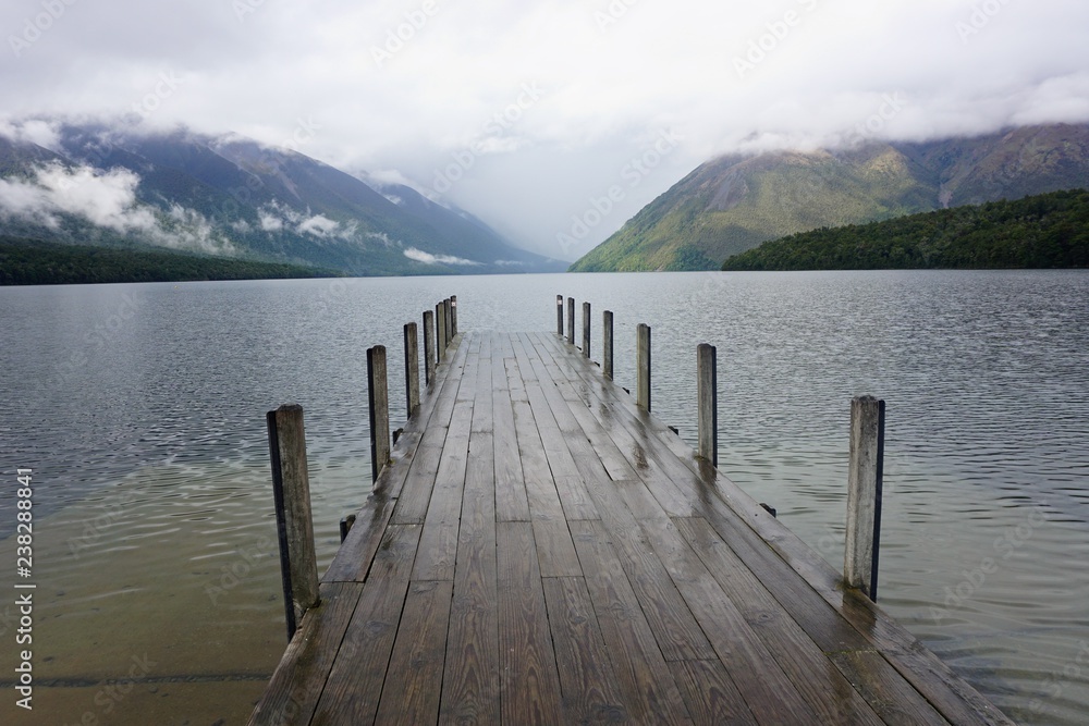 Fototapeta Lake Rotoiti Jetty early in the Morning with Fog lifting off the Mountains, South Island, New Zealand