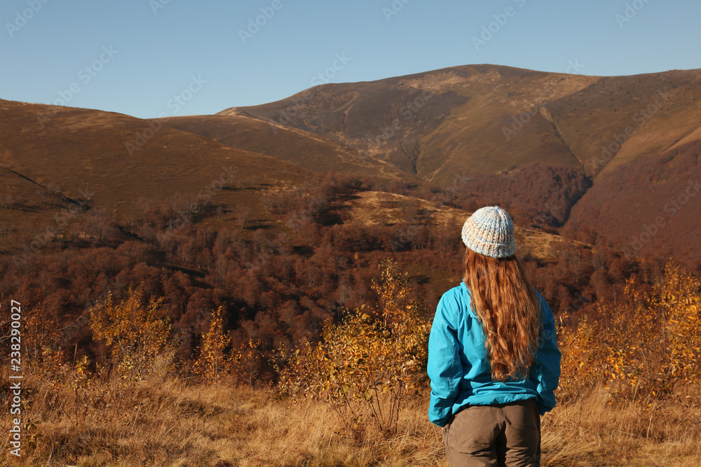 Woman in warm clothes enjoying mountain landscape