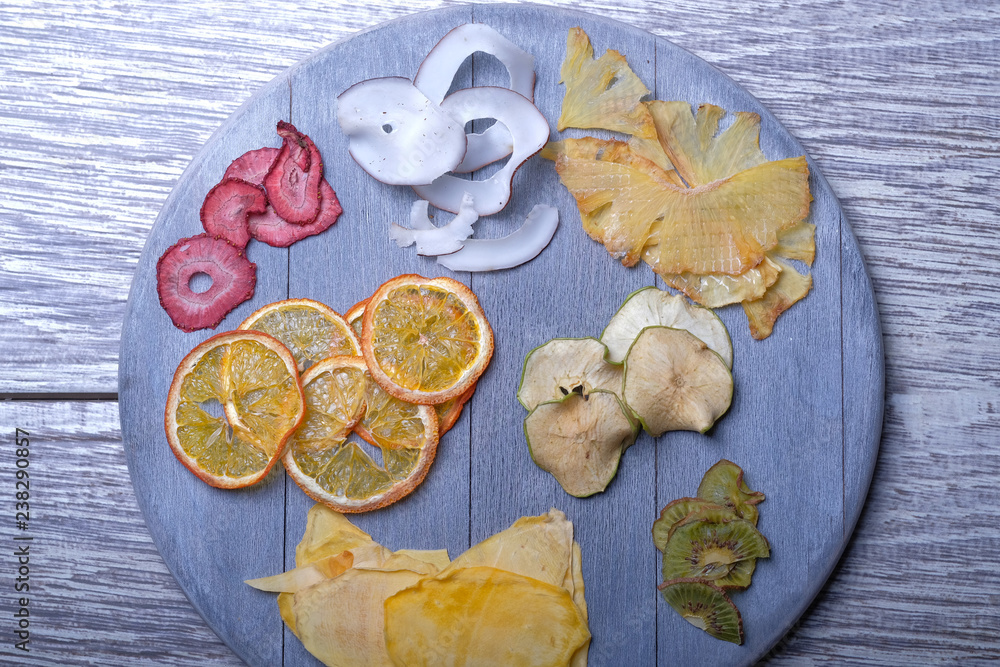Dried fruits in wooden tray on gray wooden background Dried fruits in wooden tray on gray wooden background