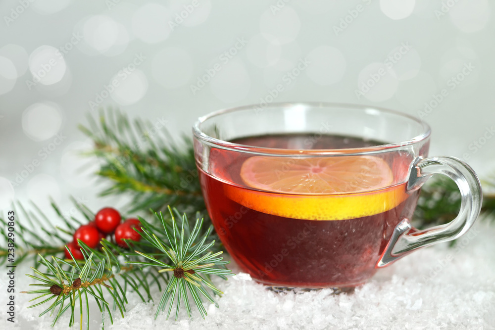Christmas tea in transparent cup on snowy background. Winter holiday concept Christmas tea in transparent cup on snowy background. Winter holiday concept