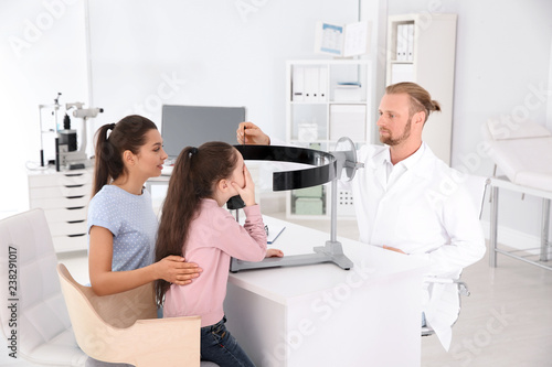 Children s doctor examining girl s vision at office