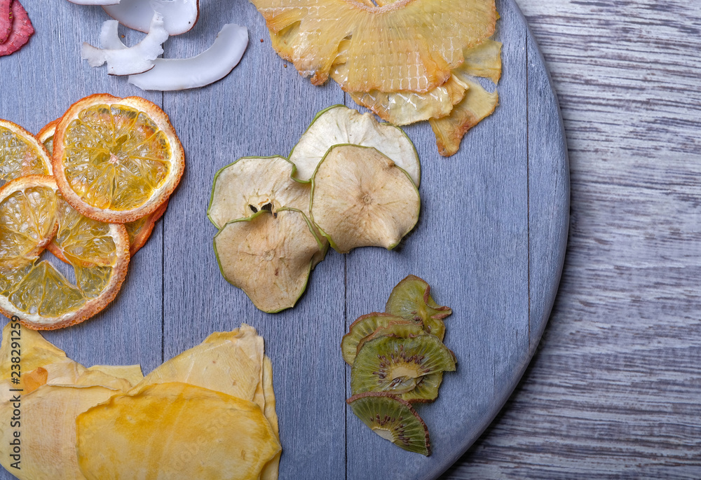 Dried fruits in wooden tray on gray wooden background Dried fruits in wooden tray on gray wooden background