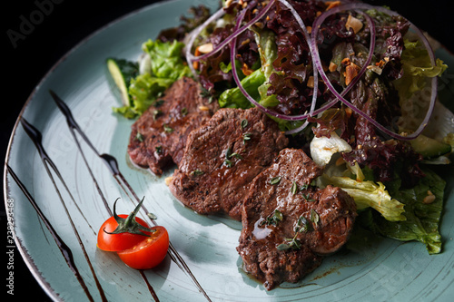 Grillades with vegetables on a black background photo