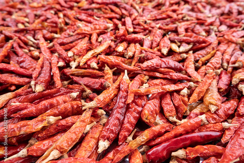 Pile of dried red chili peppers background, food ingredient.