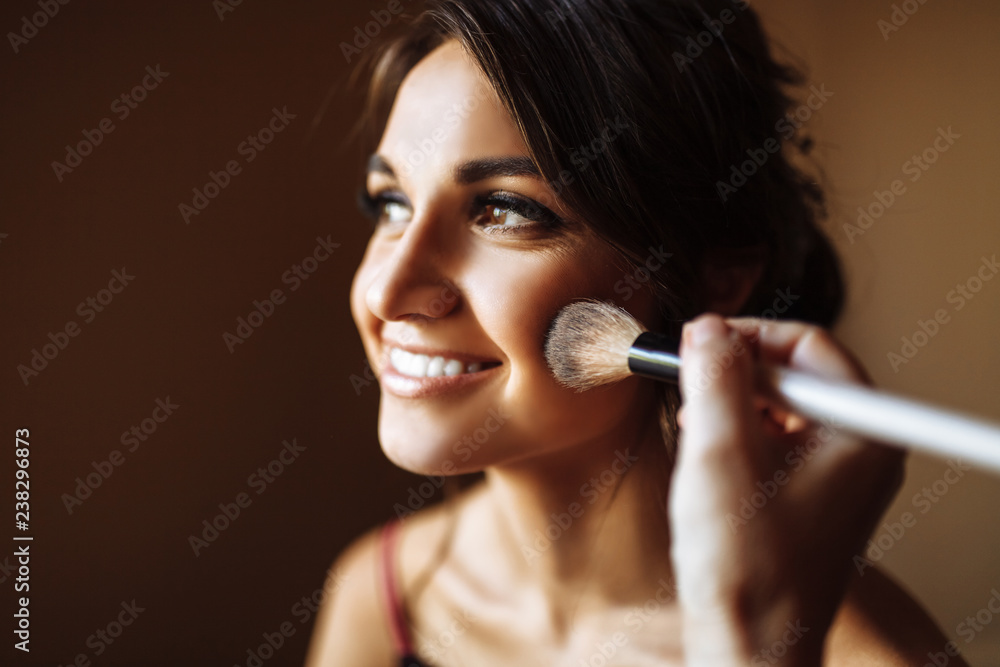 Obraz premium Beautiful bride, makeup artist does the wedding makeup to the girl