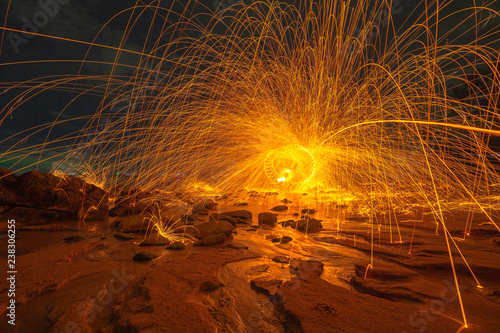 .cool burning steel wool art fire work photo experiments on the beach at sunset