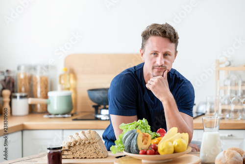 Healthy man in the kitcken with wholesome food on the table