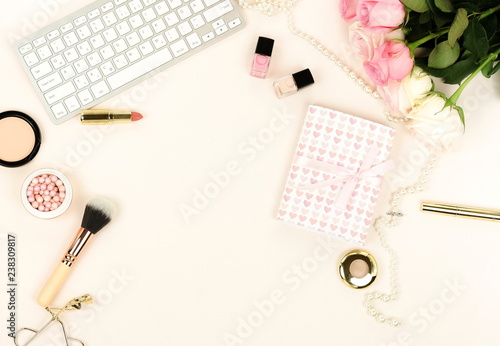 Flat lay women's office desk workplace with flowers. Female workspace with keyboard, flowers pale pink roses, gifts, makeup accessories on white background. Top view feminine background.Copy space