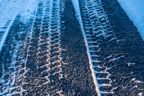 Snowy tire tracks on an asphalt road 