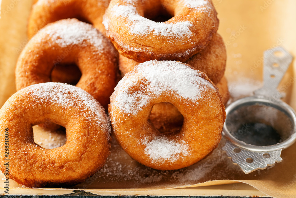 Homemade donuts  with powdered sugar on a wooden baclground
