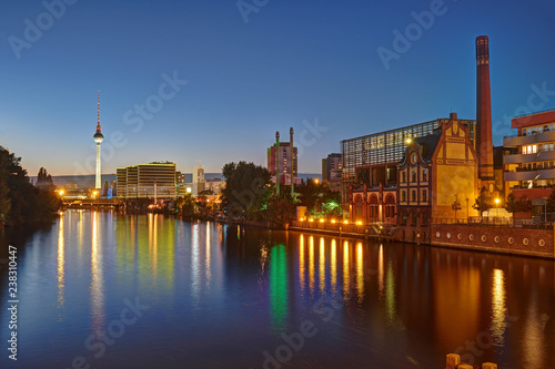 The River Spree in Berlin with some old industrial buildings and the Television Tower in the back at night