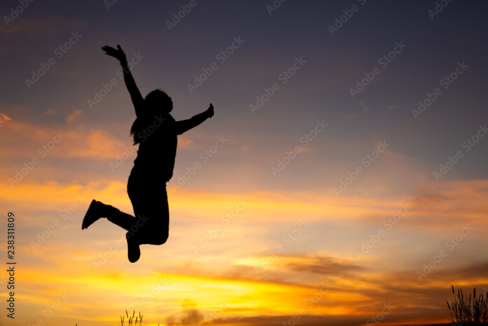 happiness, freedom, motion and people concept - smiling young woman jumping in air sunset background