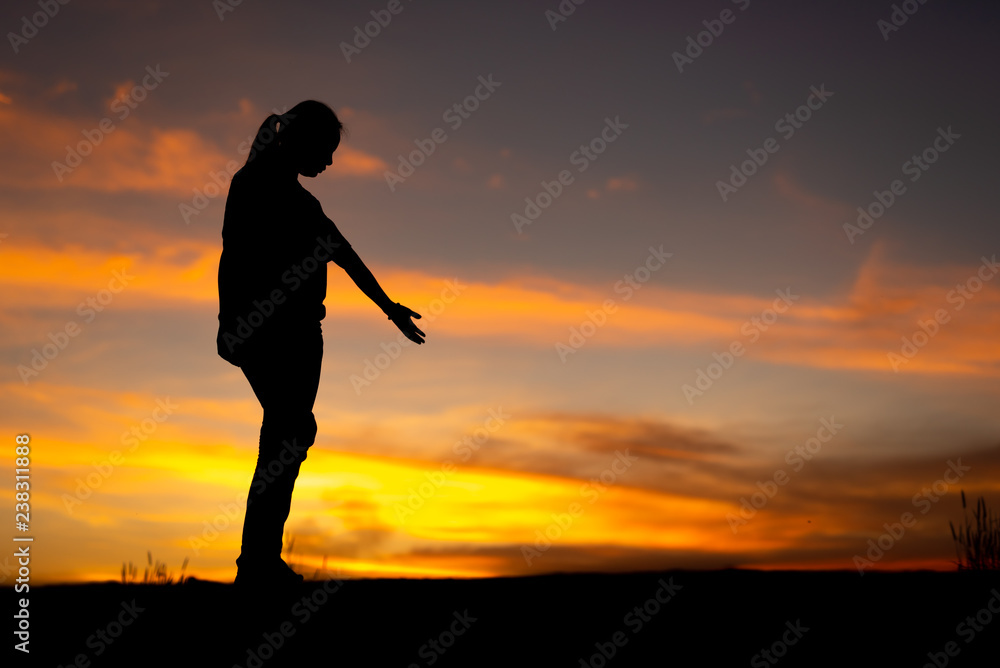 Silhouette of sad and depressed women walking at walkway of park with sunset