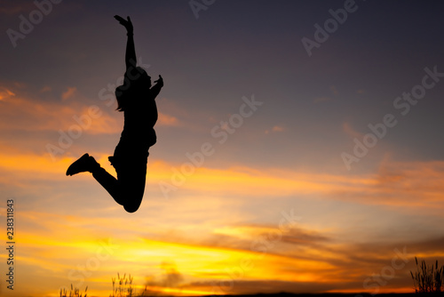 happiness, freedom, motion and people concept - smiling young woman jumping in air sunset background © stcom