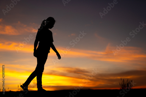Fototapeta Naklejka Na Ścianę i Meble -  Silhouette of sad and depressed women walking at walkway of park with sunset