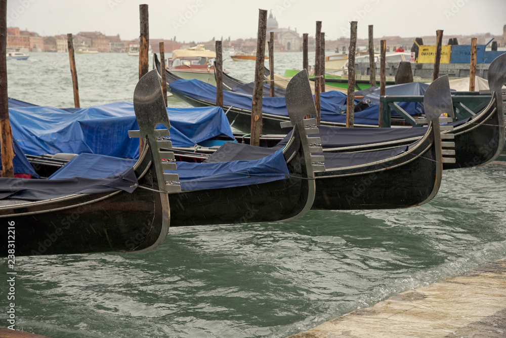 Zugedeckte venetianische Gondel schauckeln bei Hochwasser in Venedig