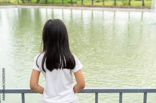Portrait back child girl Asian pond