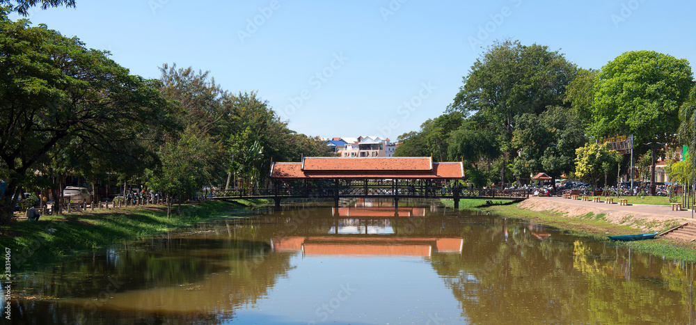 Obraz premium A bridge in Siem Reap with reflections in the river, Cambodia