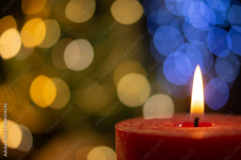 Lighted candle on the blurred light blue and golden spots background Lighted candle on the blurred light blue and golden spots background