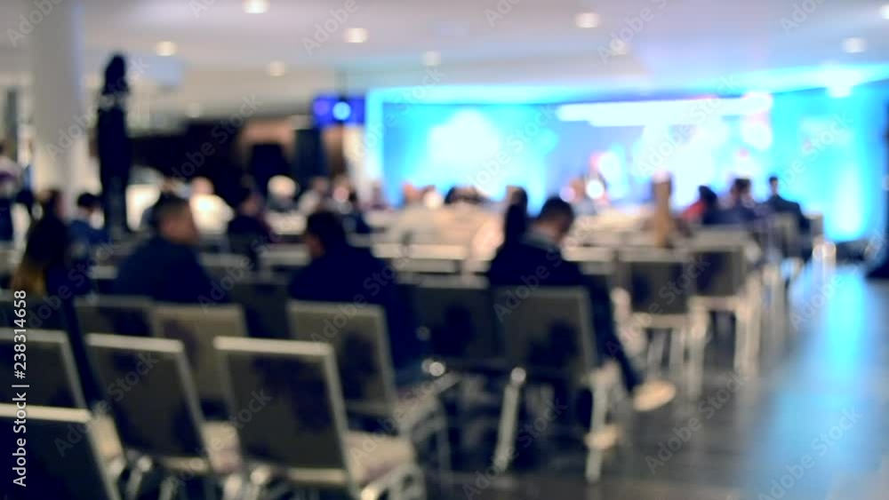 Blurred Background. Many people are sitting in the hall audience listening to presentation lecture speech at forum or conference. Neon lights