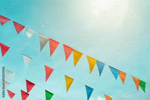 Fototapeta Naklejka Na Ścianę i Meble -  Fair flag bunting colorful background hanging on blue sky for fun fiesta party event, summer holiday farm feast celebration, carnival festival event, park or street festa design decoration