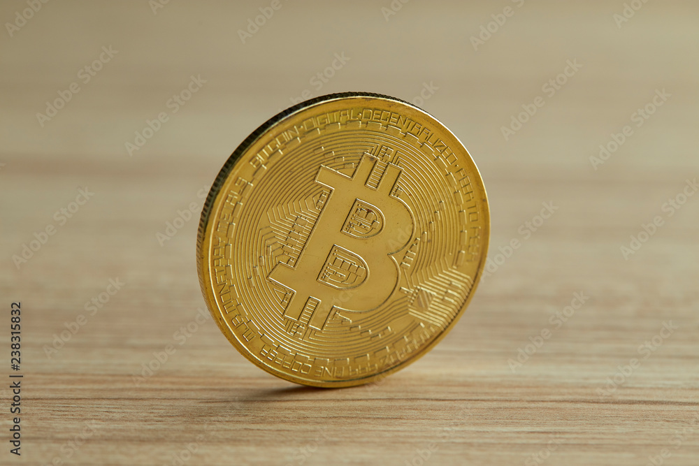 Golden Bitcoin coin on wood background Golden Bitcoin coin on wood background