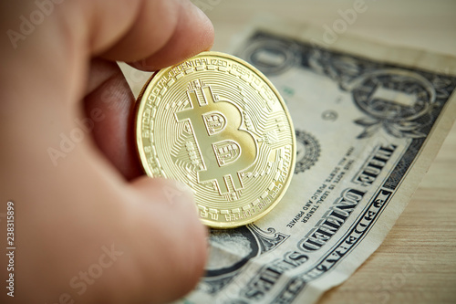 Golden Bitcoin coin on wood background