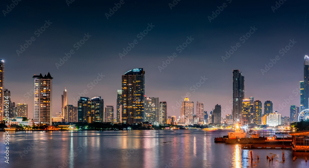 Cityscape of modern building near the river in the night. Modern architecture office building. Skyscraper with evening sky. Black and white tone picture. Night photography of riverfront building.