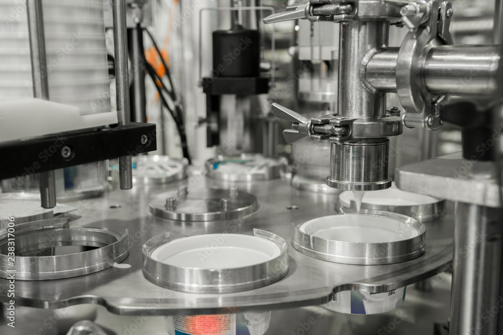 production and bottling of yogurt in plastic cups. equipment at the dairy plant production and bottling of yogurt in plastic cups. equipment at the dairy plant