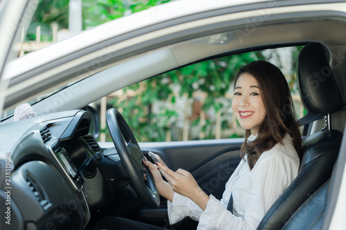A beautiful young woman in a good mood are traveling by car.