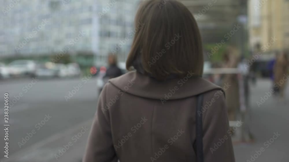 Woman slowly walking to bus stop, regular way to work, public transportation Woman slowly walking to bus stop, regular way to work, public transportation
