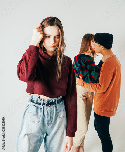 Fotografie, Obraz Sad young teen girl on background of loving couple, isolated. Th