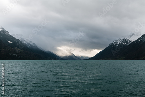 Panoramic view from Brienz village town city on Morgenberhorn mountain spot-lit with the sun through dramatic thunder clouds photo