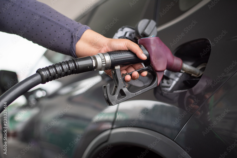 Pumping equipment gas at gas station. Close up of a hand holding fuel nozzle Pumping equipment gas at gas station. Close up of a hand holding fuel nozzle