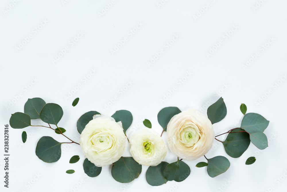 Fototapeta premium Flower spring frame with fresh branches of ranunculus and pion roses and eucalyptus leaves isolated on white background, flat lay and top view