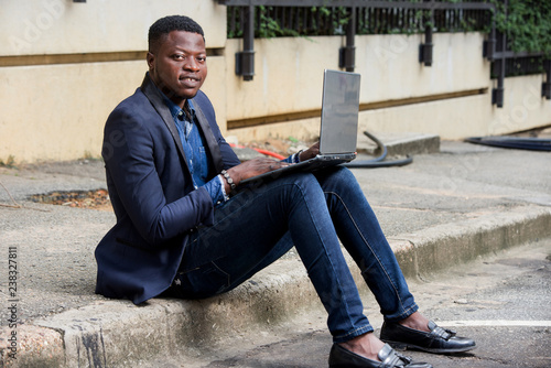 Businessman sat outside modern office block