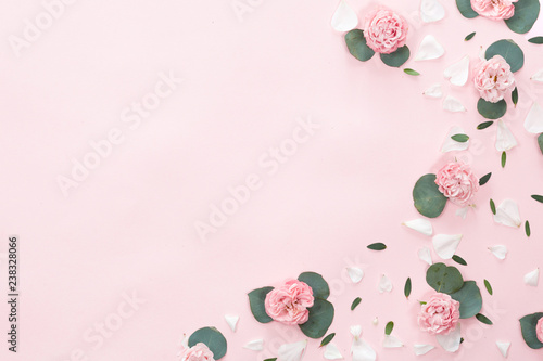 Flat lay of green leaves frame on pink background, top view with
