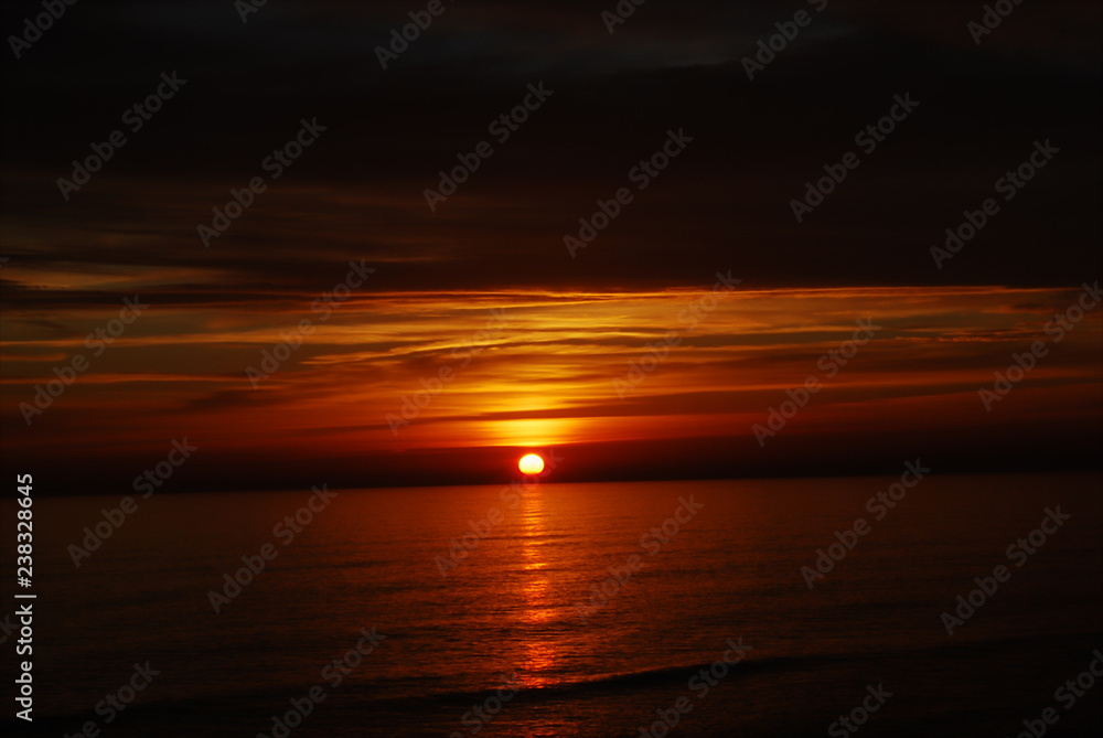 the sun sets over the sea