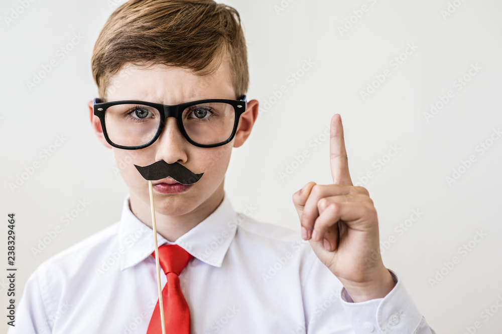Serious boy standing with a finger in big glasses. The concept of the evil boss Serious boy standing with a finger in big glasses. The concept of the evil boss